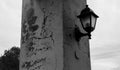 Old lantern on the cracked column with background on the sky