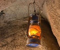an old lantern hangs from a rock above a fire pit