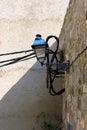 Old lantern on the structural medieval wall and modern electrical cables. Royalty Free Stock Photo