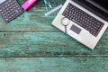 Old laptop with office equipment on wood background