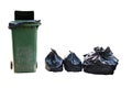 Old large green wheel bin and pile of full garbage bags Royalty Free Stock Photo