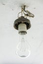 An old large incandescent lamp hangs on the ceiling
