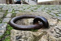 Old large rusty metal ring for mooring boats in the river Royalty Free Stock Photo