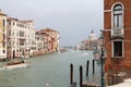 Old large water canal in Venice, with boats, wooden piles stuck in the water, colorful buildings sunk in sea water Royalty Free Stock Photo