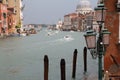 Old large water canal in Venice, with boats, wooden piles stuck in the water, colorful buildings sunk in sea water Royalty Free Stock Photo