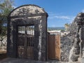 Old lava stone and wooden rustic door, blue house, white apartments, palm trees, green hills and blue sky at Canary Royalty Free Stock Photo