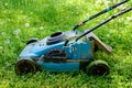 Old lawnmower on green grass in the park Royalty Free Stock Photo