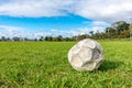 Old leak football/soccer ball abandoned on green grass field. Concept of sadness, hopeless and loneliness Royalty Free Stock Photo