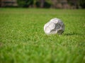 Old leak football/soccer ball abandoned on green grass field. Concept of sadness, hopeless and loneliness Royalty Free Stock Photo