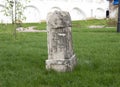 An old leaning stone tombstone with a cross Royalty Free Stock Photo