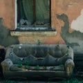 old leather abandoned sofa on the street at the facade of the destroyed house with window, the plants sprouted through the