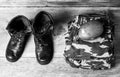 Old leather black men`s army boots, military uniform and water flask on a wooden background close-up view from above, black and w Royalty Free Stock Photo