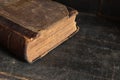 Old leather bound book laying on a dusty wooden bookshelf Royalty Free Stock Photo