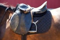 Old leather saddle with stirrups for show jumping race Royalty Free Stock Photo