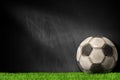 Old soccer ball on the green grass with empty blackboard Royalty Free Stock Photo