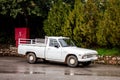 The old legendary vintage Mazda B1600 pickup parked on a wet road in front of trees in Greece where these Japanese vehicles are ve