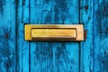 Old letterbox or mailbox slot on worn wooden blue door Royalty Free Stock Photo