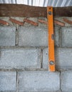 Old level ruler is hanging on the brick wall. Royalty Free Stock Photo