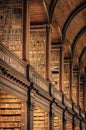 Old library interior with ornate wooden architecture and endless bookshelves Royalty Free Stock Photo