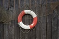 Old lifebelt and fishing net hanging on the wooden wall Royalty Free Stock Photo