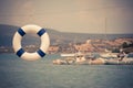 Old lifebelt hanging and fishing boats in the background Royalty Free Stock Photo