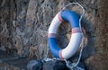 Old lifebuoy next to stone wall by the sea. Marine retro background Side view