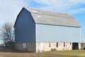 Old light blue barn with a field stone foundation on a farm in late autumn on a sunny day Royalty Free Stock Photo