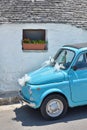 Old light blue tiny cute italian car decorated for marriage parc