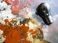 Old light bulb on a water surface with pieces of old peeled red paint Royalty Free Stock Photo