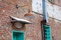 Rustic details on the side of a colorfully painted old brick building. Royalty Free Stock Photo
