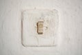 Old light switch on a white old wall on a traditional house in Romania Royalty Free Stock Photo