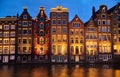 Old lighted houses bulidings at lighted sunset river channel in Amsterdam city