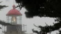 Old lighthouse fresnel lens glowing, foggy rainy weather. Illuminated beacon USA Royalty Free Stock Photo