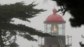 Old lighthouse fresnel lens glowing, foggy rainy weather. Illuminated beacon USA Royalty Free Stock Photo