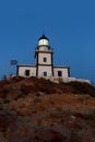The Old Lighthouse On The Rocky Cliff At Night.