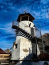 Old lighthouse with white facade and wooden roof in details