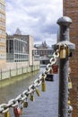 On an old link chain of the Speicherstadt in Hamburg hang many colorful so-called love locks in different shapes. The Royalty Free Stock Photo