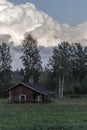 Old little house in Finland under amazing clouds