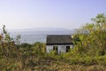 An old little hut on a mountain in the village of Luxiang in China. Behind the house you can see the sea and the horizon Royalty Free Stock Photo