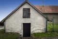 Old little white house with a wooden window and a door and garden