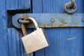 Old Lock on Blue Wood Door. Old-fashioned latch on the door, retro style. Old closed padlock rusty on barn wooden