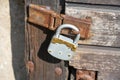 Old lock hangs on the wooden door of an old barn. Vintage old padlock Royalty Free Stock Photo