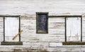 Old locked weathered window and two barn doors on country building, white peeling paint Royalty Free Stock Photo