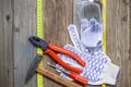 Old locksmith tools, work gloves, safety glasses and measuring tape on aged textured surface