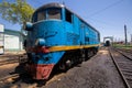 An old locomotive car is being repaired in a railway depot