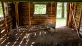 Old log cabin interior with a rusted spring bean on a dirt floor Royalty Free Stock Photo