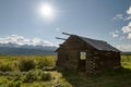 Old log cabin on a meadow near Stanley Idaho with Sawtooth mountains