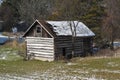Old log cabin storage building in the woods with light snow in winter Royalty Free Stock Photo