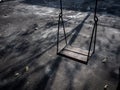 Old lonely wooden swing on sunset time with light and shadow Royalty Free Stock Photo