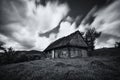 An old, long-abandoned house, against the background of a cloudy sky, shot on a long exposure. Abandoned house in West Ukraine.Old